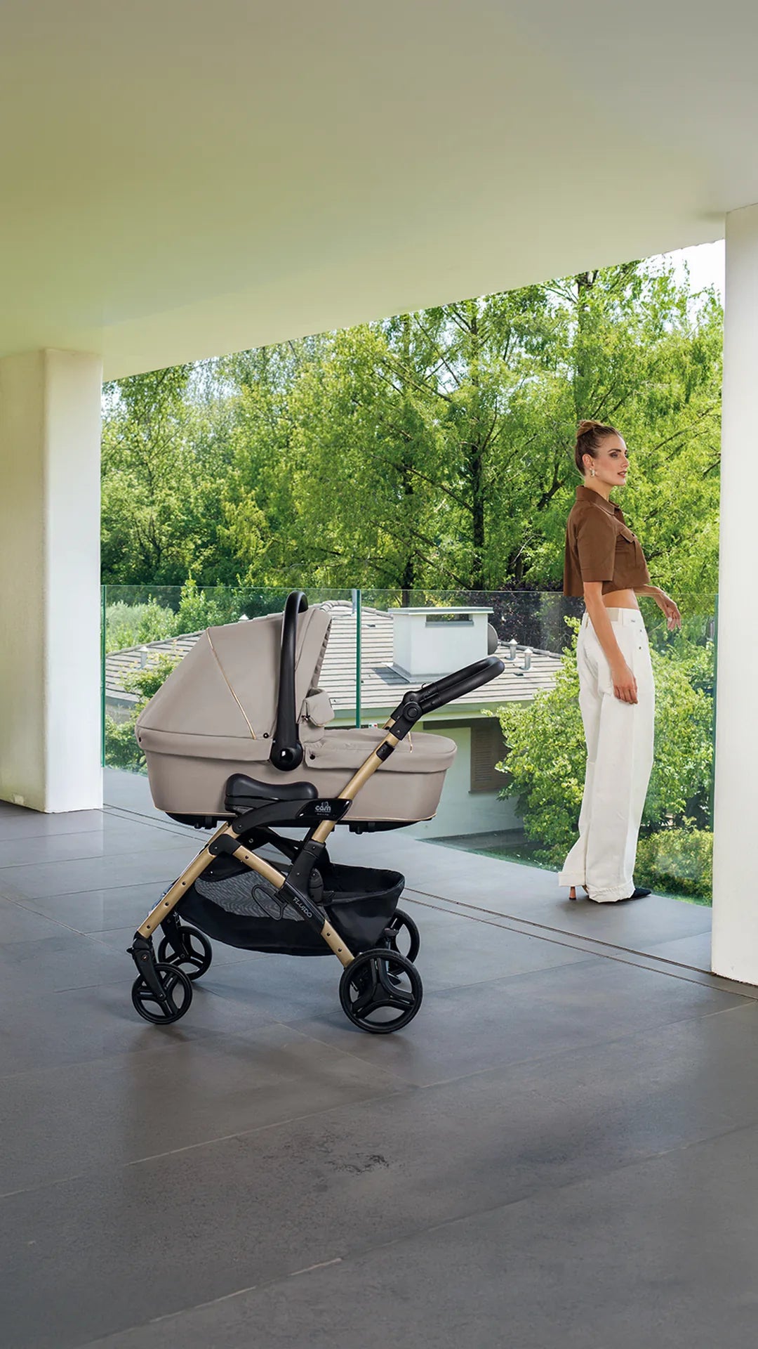 A mother pushing a baby in a CAM stroller through a sunlit Italian street.